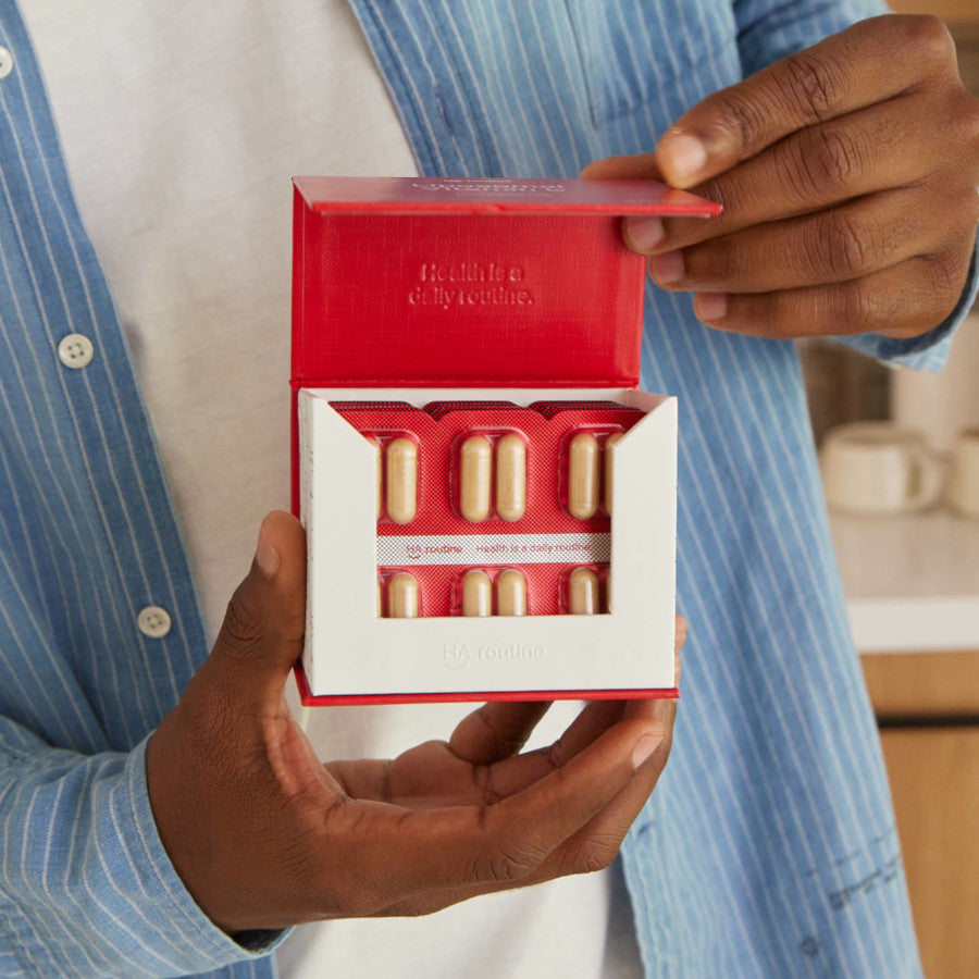 man holding open a box of haroutine liposomal vitamin c capsules